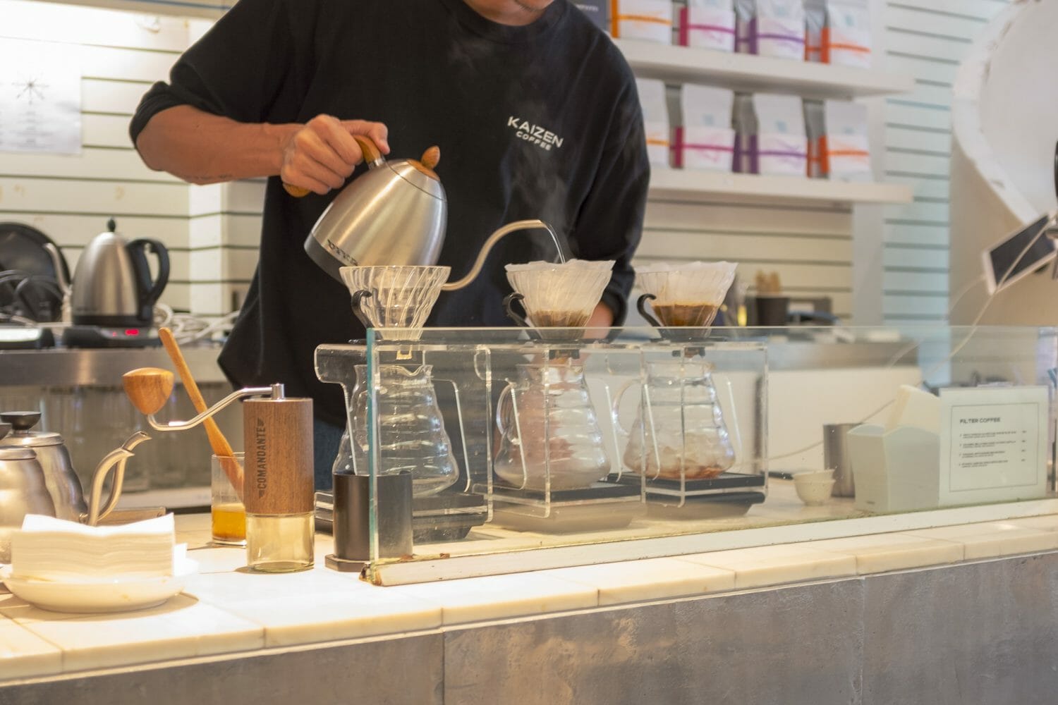 Barista pouring a V60 at Kaizen coffee in Bangkok.