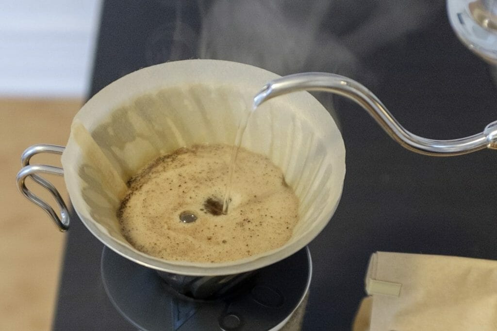 Closeup of coffee spout pouring water into a Hario V60 which is compared in this fellow stagg x review