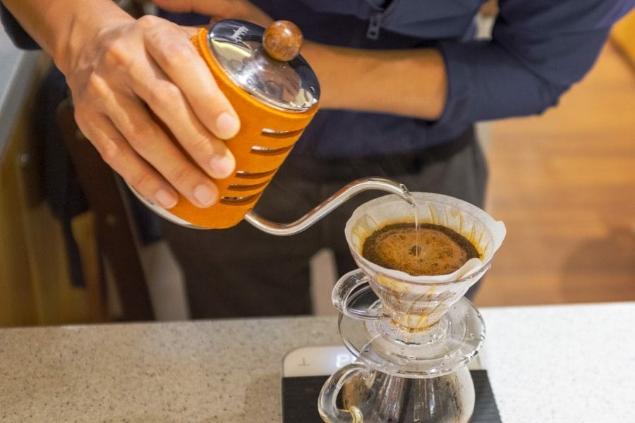Hario V60 guide with a photo of a barista pouring water over coffee